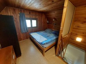 1 dormitorio pequeño con 1 cama en una cabaña de madera en Chata v Jedovnicích u rybníka Olšovec, en Jedovnice