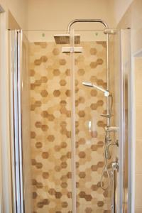 La salle de bains est pourvue d'une douche avec une porte en verre. dans l'établissement nonnanina, à Pisticci