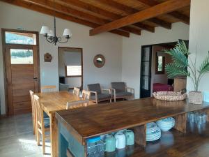 a dining room and living room with a wooden table at Cabañas Tierra Verde in El Bolsón
