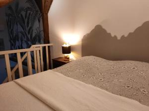 una camera da letto con un letto e una lampada su un tavolo di Gîte de charme - La Cure Pontlevoy a Pontlevoy