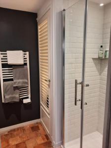 bagno con doccia e asciugamani appesi a una parete di Gîte de charme - La Cure Pontlevoy a Pontlevoy