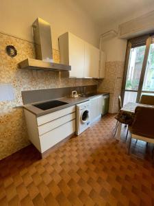 a kitchen with a sink and a washing machine at Hostel Corner 32 in Milan