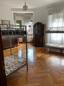 two bunk beds in a room with a wooden floor at Hostel Corner 32 in Milan