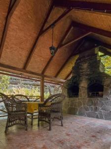 a patio with chairs and a stone fireplace at Elf-cottage in Tur'ya Pasika