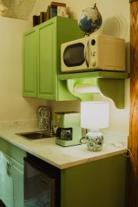 a kitchen with green cabinets and a microwave at Landoll's Mohican Castle in Loudonville