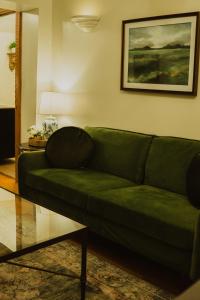 un sofá verde en la sala de estar en Landoll's Mohican Castle, en Loudonville