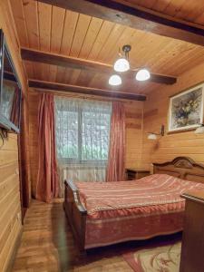 Schlafzimmer mit einem Bett und einem Fenster in der Unterkunft Elf-cottage in Turʼya Paseka