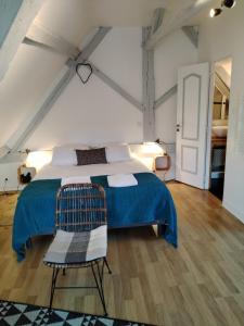 a bedroom with a blue bed and a chair at Appartement Henri II in Le Mans