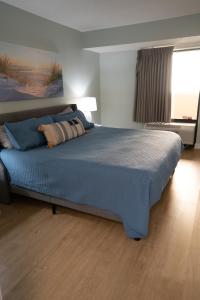 a bedroom with a large bed with a blue blanket at Sunny Seaside Escape Perfect for Couples in Myrtle Beach