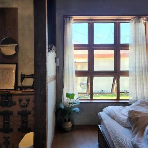 a bedroom with a bed and a large window at Jeju Deluang Gimnyeong 1236 in Jeju