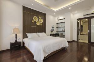 ein Schlafzimmer mit einem großen weißen Bett und einem Spiegel in der Unterkunft Hanoi Premium 160 Sqm Apt with Top-Quality Furnishing in Hanoi