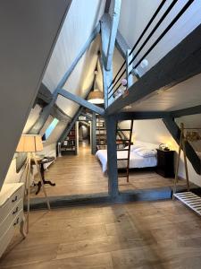 a attic bedroom with a bunk bed and a desk at Manoir de l'Aumônerie in Saint-Martin-de-Boscherville