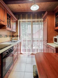 a kitchen with a table and a large window at Elf-cottage in Tur'ya Pasika