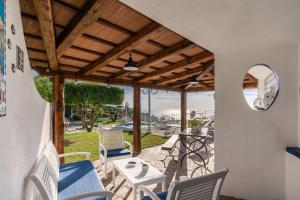 patio z krzesłami, stołem i lustrem w obiekcie Villa Marika - PRIVATE HEATED POOL w mieście Massa Lubrense