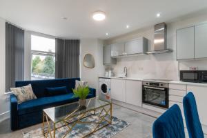 een woonkamer met een blauwe bank en een tafel bij Cardiff Luxe Living Apartments in Cardiff