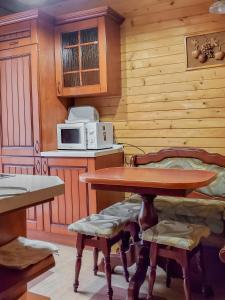 eine Küche mit einem Tisch und einer Mikrowelle in der Unterkunft Elf-cottage in Turʼya Paseka