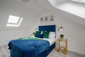 Schlafzimmer mit einem blauen und weißen Bett und einem Tisch in der Unterkunft Cardiff Luxe Living Apartments in Cardiff
