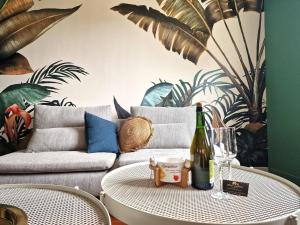 - un salon avec un canapé et une table avec une bouteille de vin dans l'établissement Bonheur dans le Finistère cosy jardin 2-8 pers, à Névez