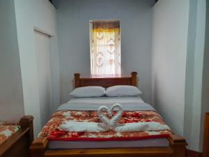 een bed met twee witte handdoeken en een raam bij Ruchi House in Nuwara Eliya