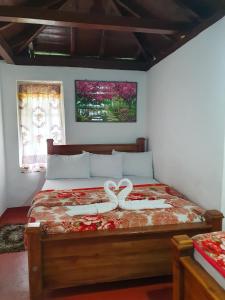 a bedroom with a bed with two white bows on it at Ruchi House in Nuwara Eliya