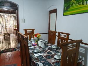 a table with plates and cups on top of it at Ruchi House in Nuwara Eliya