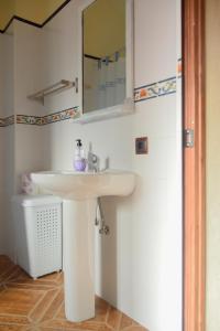 bagno con lavandino bianco e specchio di casa celeste ad Algodonales