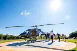 un grupo de personas de pie junto a un helicóptero en La Terra Dei Sogni Country Hotel, en Fiumefreddo di Sicilia