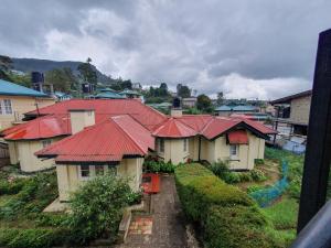 eine Gruppe von Häusern mit roten Dächern in der Unterkunft Ruchi House in Nuwara Eliya