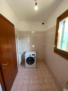 y baño pequeño con lavadora y secadora. en Villetta Diana Cozy House, en Piazzola sul Brenta