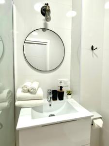 y baño con lavabo blanco y espejo. en BuenaVista Gigantes Marina - Room with Private Bathroom en Acantilado de los Gigantes