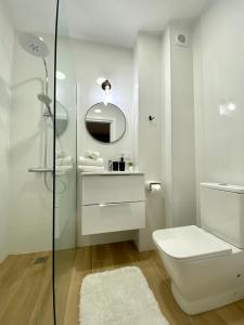 y baño blanco con aseo y ducha. en BuenaVista Gigantes Marina - Room with Private Bathroom en Acantilado de los Gigantes