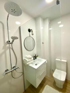 y baño con lavabo, aseo y espejo. en BuenaVista Gigantes Marina - Room with Private Bathroom en Acantilado de los Gigantes