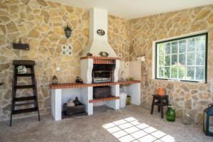 cocina con fogones y pared de piedra en Casa da Hera, en Ericeira