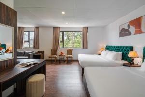 een hotelkamer met een bed en een bureau bij TTR Moonstone Apart Hotel in Da Lat