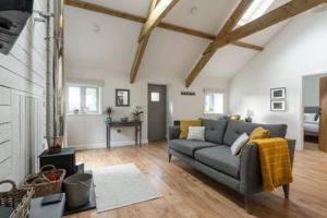 a living room with a gray couch in a room at Gilliflower 1 bedroom cottage at Trethwale Barns Holiday Home in Saint Keyne