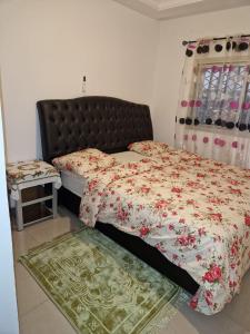 um quarto com uma cama com um edredão florido em Residence Les Bourgeois appartementen. em Iaundé