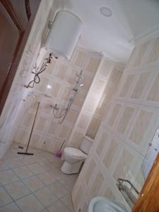 uma casa de banho com um WC e uma cabina de duche. em Residence Les Bourgeois appartementen. em Iaundé