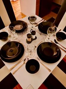 a table with black plates and wine glasses on it at Lux 05 in Lukavica