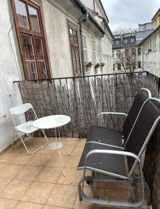 un patio avec deux chaises et une table sur un balcon dans l'établissement 120 m2 apartment in the centre of the old town, à Bratislava