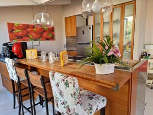 a kitchen with a large wooden counter with chairs at Luxury Panoramic Loft with heated saltwater pool and parking near Taormina, Catania, the Sea and Mount Etna by SicilianRelaxingHomes in Giarre