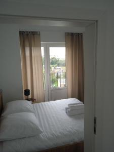 sypialnia z białym łóżkiem i oknem w obiekcie Apartament Panorama Kalisz Złota 71 w Kaliszu