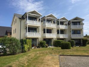 an apartment building with balconies and a yard at Ferienwohnung Ankerplatz in Glowe