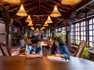 dwoje ludzi siedzących przy stole w restauracji w obiekcie Madpackers Goa w mieście Anjuna
