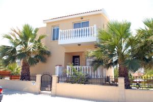 ein Haus mit Palmen davor in der Unterkunft Diamond Villas in Paphos City