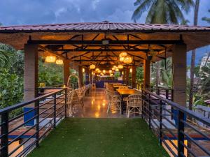 a restaurant with tables and chairs under a pergola at Madpackers Goa in Anjuna