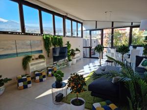 un salon rempli de nombreuses plantes dans l'établissement Luxury Relaxing Home with heated pool near Catania, Taormina, the Sea and Mount Etna, à Giarre