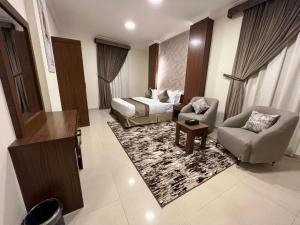 a hotel room with a bed and a couch and chairs at سمو سويت للشقق المخدومة 2 Smo Suites in Riyadh
