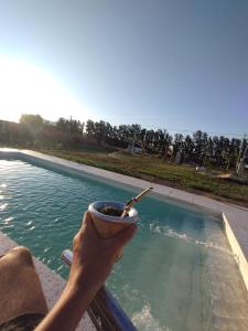 een persoon met een kopje koffie naast een zwembad bij Bungalows La Nicasia de San Pedro in San Pedro