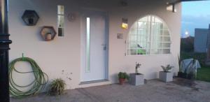 een wit huis met een deur en wat planten bij Bungalows La Nicasia de San Pedro in San Pedro