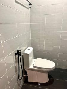 a bathroom with a white toilet and a shower at CASA ADELIA STUDIO SUNGAI KARANG BALOK in Kampung Sungai Karang